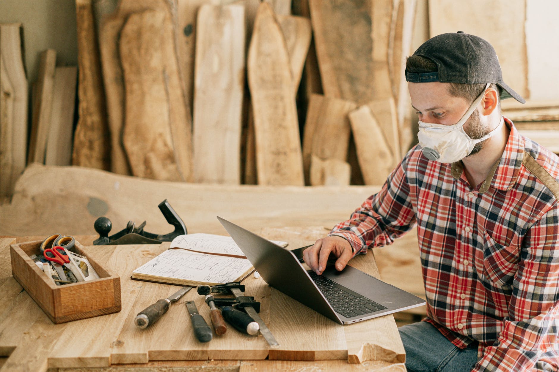 Man using a laptop at a wood workshop  Photo by Ivan Samkov on Pexels.com