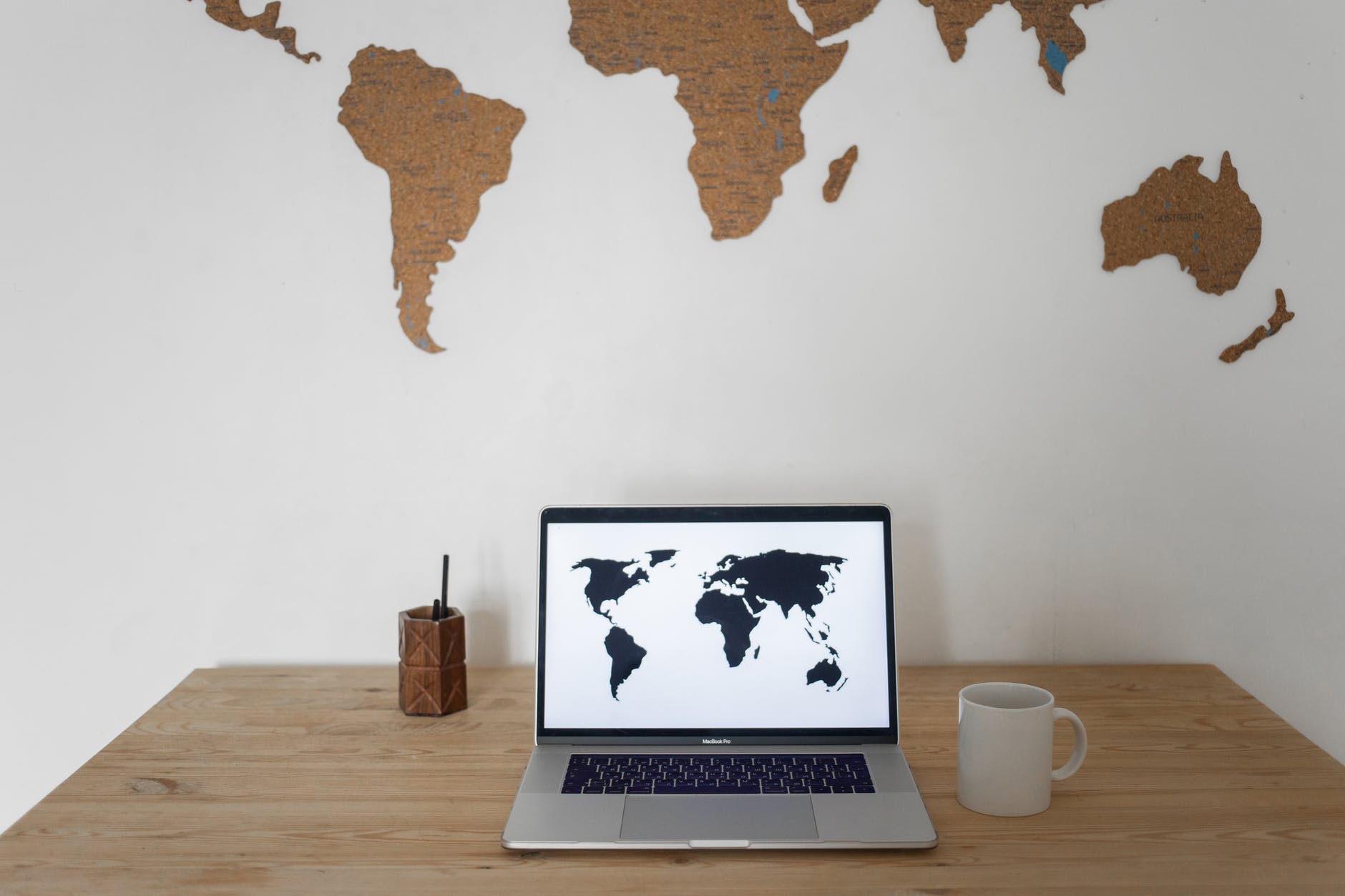 World map on wall and remote working laptop near cup and container - Global business travel  Photo by Monstera on Pexels.com