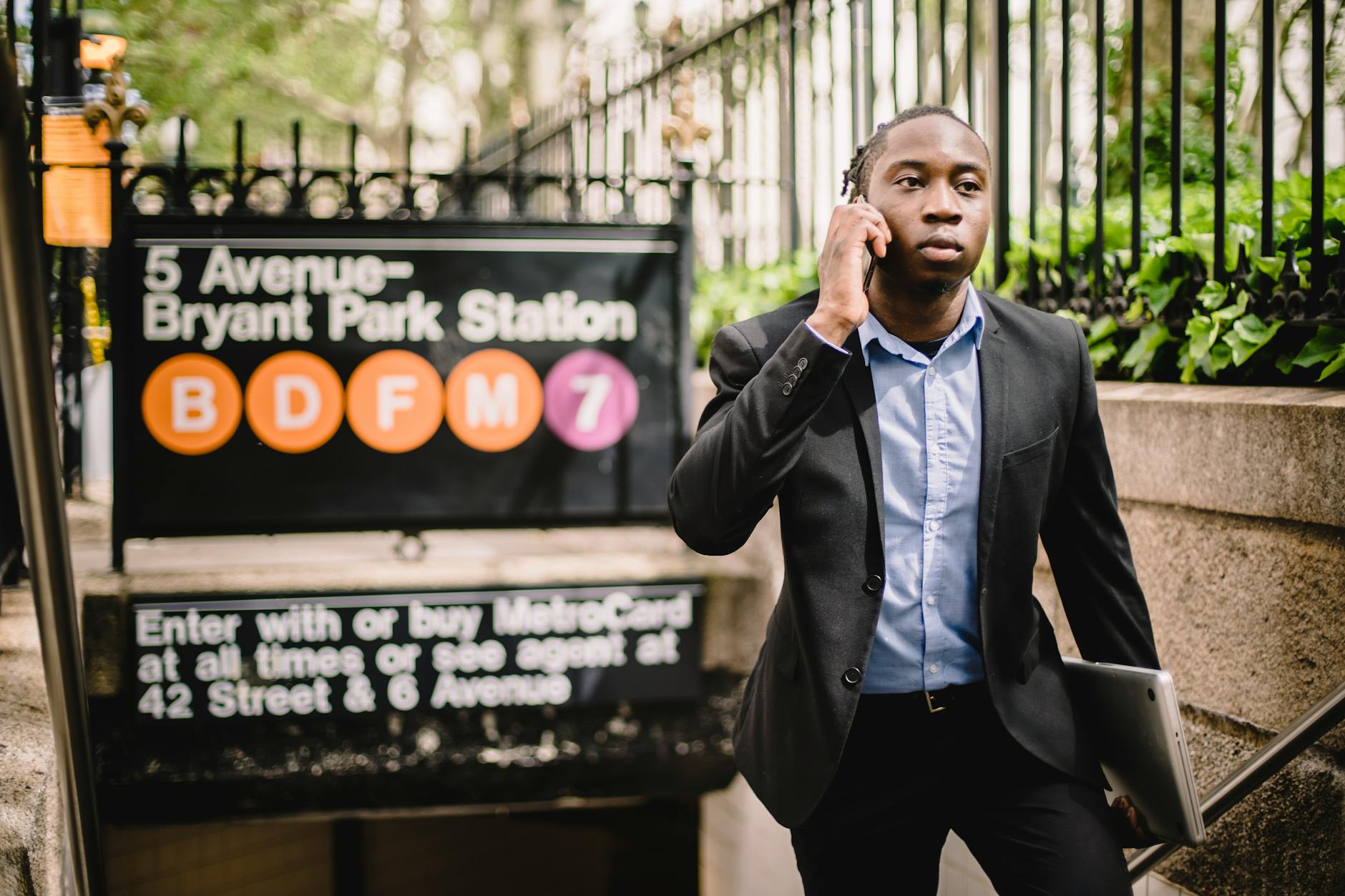 serious black businessman talking on smartphone on street